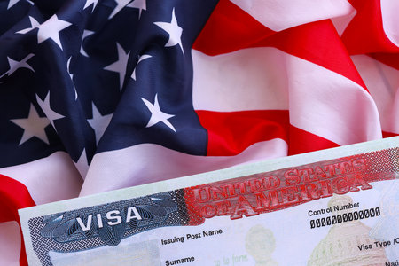 U.S. VISA United States of America. American Tourist or Green Card Visa on flag background close upの写真素材