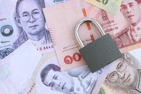 Thai baht currency money bills and padlock close up. The concept of sanctions and financial safety