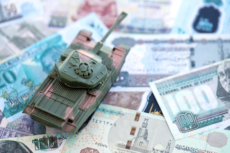 Egyptian pound currency money bills and toy tank close up. The concept of army funds and weapons salesの写真素材