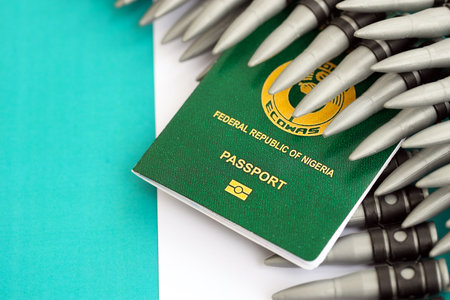 Nigerian passport and rifle bullets on flag close up. The concept of warfare and gun sellingの写真素材