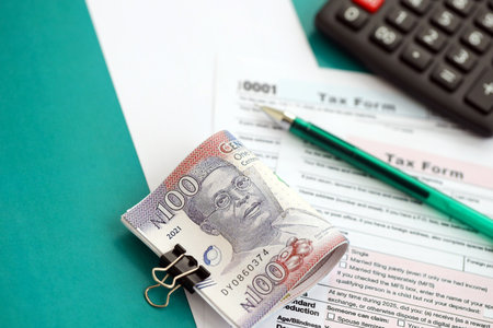 Nigerian naira money bills and calculator with tax form on flag close up. Taxation and accounting...
