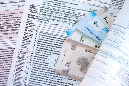 United Arab Emirates dirham money bills on tax form close up. Taxation and accounting concept