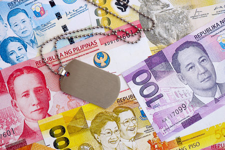 Philippines peso currency money bills and military token close up. The concept of army serviceの写真素材