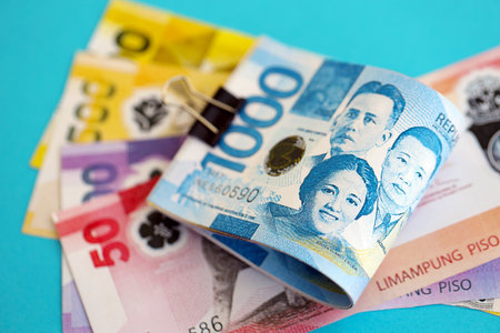 Philippines peso money bills in big amount close up on blue. Finance and banking conceptの写真素材