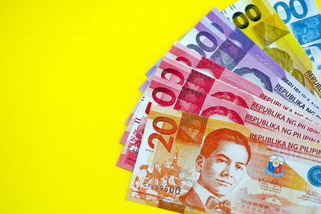 Philippines peso money bills in big amount close up on yellow. Finance and banking conceptの写真素材
