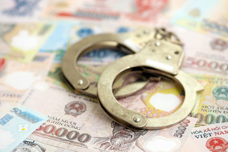 Vietnamese dong currency money bills and handcuffs close up.の写真素材
