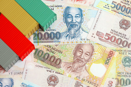 Vietnamese dong currency money bills and toy cargo containers close up. The concept of shipping and logisticsの写真素材