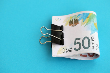 Israel New Shekels banknotes on blue background. The current Israel money bills lies on blue in big...
