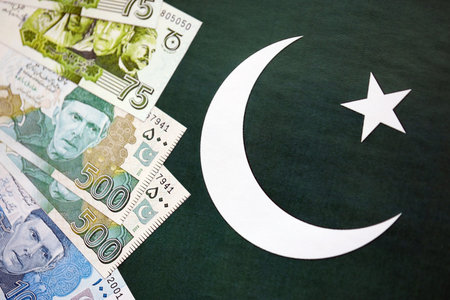 Pakistan rupees banknotes on Pakistani flag background. The current Pakistan money bills lies on banner in big amount. The concept of economics and business in Pakistanの写真素材