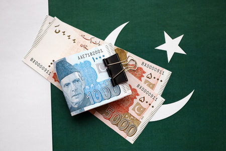 Pakistan rupees banknotes on Pakistani flag. The current Pakistan money bills lies on banner in big amount. The concept of economics and business in Pakistanの写真素材