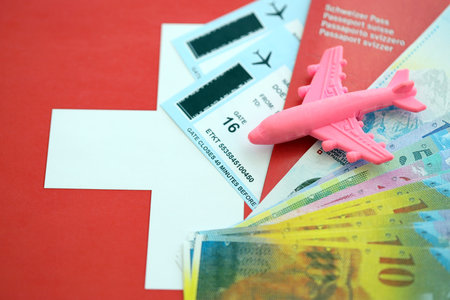 Swiss franc banknotes and passport with tickets on flag. The current francs money bills and biometrical pass lies on flag. The concept of travel and vacation in Switzerlandの写真素材