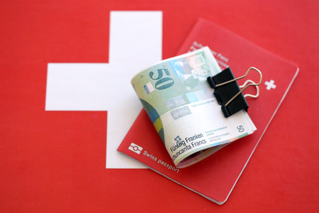 Swiss franc banknotes and passport on flag. The current money bills lies on flag with pass. The concept of business and investment in Switzerlandの写真素材