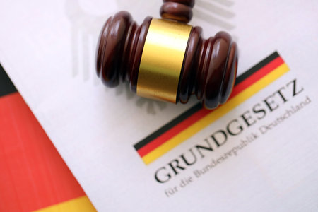 The constitution basic law book of Germany and judge hammer lies on Germany flag background close upの写真素材