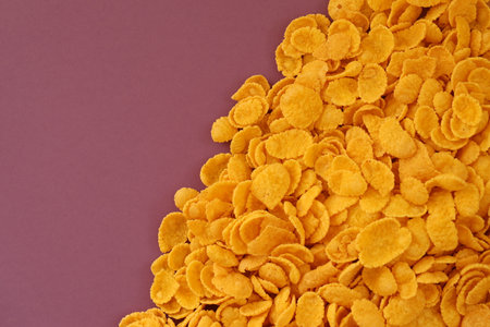 Background of breakfast cereals in big amount on purple background close up, top viewの写真素材