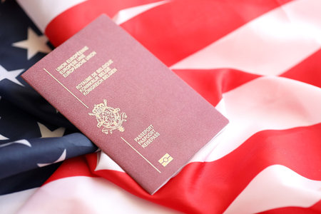 Belgium passport on big waving flag of United States of America close up. US Visa and immigration conceptの写真素材