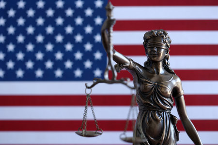 Lady Justice and American flag in the background with shallow depth of fieldの写真素材