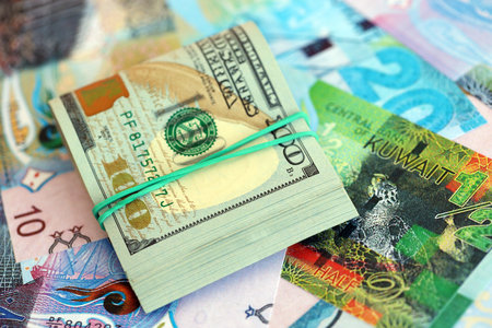 Kuwaiti dinar currency money bills and bunch of us dollar banknotes close up. The concept of economics and currency exchangeの写真素材