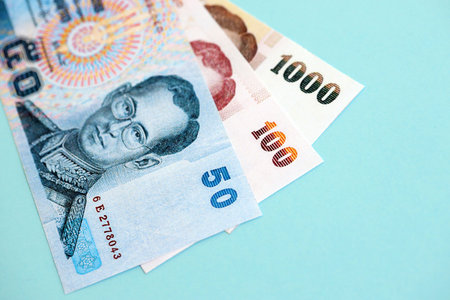 Thai baht money bills in big amount on blue close up. Finance and banking concept