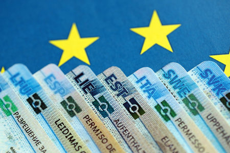 Permanent resident or residence permit cards lies on European Union flag. Paper specimen cards close upの写真素材