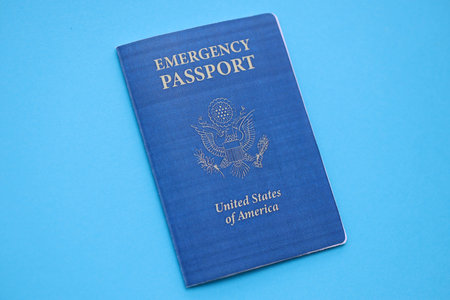 United States emergency passport book on light blue paper background close up. Travel document on blue surfaceの写真素材