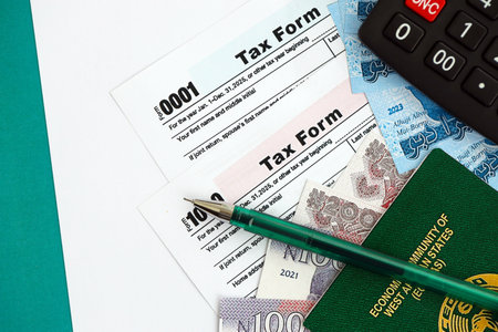 Nigerian naira money bills and calculator with tax form on flag close up. Taxation and accounting conceptの写真素材