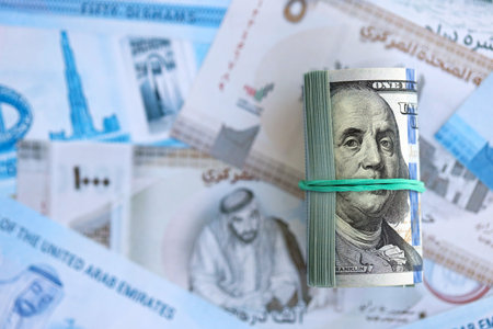 United Arab Emirates dirham currency money bills and bunch of us dollar banknotes close up. The concept of economics and currency exchangeの写真素材