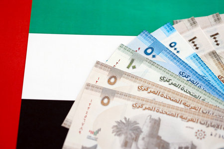 United Arab Emirates dirham currency money bills lies on flag close up. The concept of business and investmentの写真素材