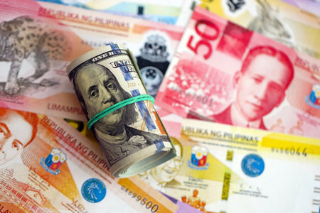 Philippines peso currency money bills and bunch of us dollar banknotes close up. The concept of economics and currency exchangeの写真素材