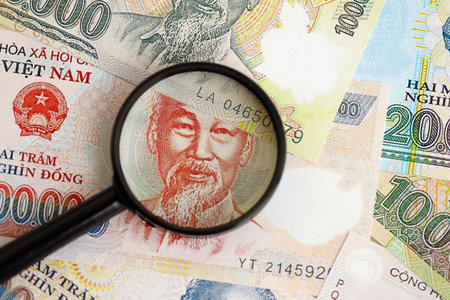 Vietnamese dong currency money bills and magnifying glass close up. The concept of financial monitoring and taxationの写真素材