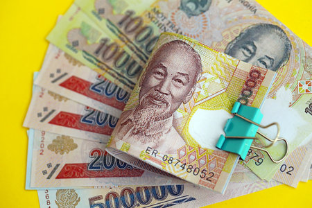 Vietnamese dong money bills in big amount close up on yellow. Finance and banking conceptの写真素材