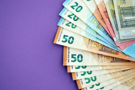 Big amount of european euro currency money notes on purple color table close up. Concept of business and income in Europeの写真素材