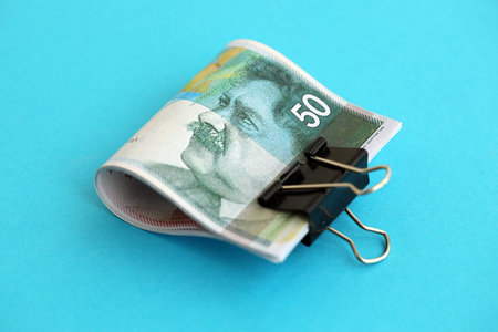 Israel New Shekels banknotes on blue background. The current Israel money bills lies on blue in big amount. The concept of business and investment in Israelの写真素材