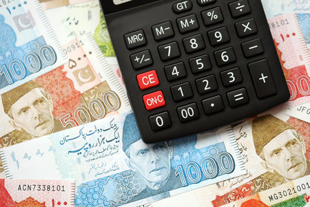 Pakistan rupees banknotes and calculator. The current Pakistan money bills and calculator lies on table in big amount. The concept of taxation and money count in Pakistanの写真素材