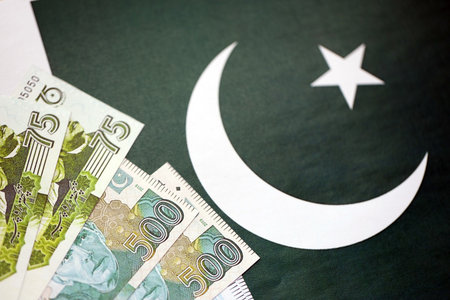 Pakistan rupees banknotes on Pakistani flag background. The current Pakistan money bills lies on banner in big amount. The concept of economics and business in Pakistanの写真素材