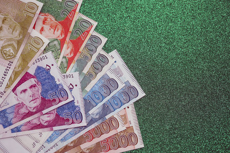 Pakistan rupees banknotes on glitter green background. The current Pakistan money bills lies on table in big amount. The concept of business and investment in Pakistanの写真素材