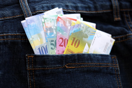 Swiss franc banknotes in denims pocket. The current francs money bills lies in jeans pocket. The concept of fashion and wealth in Switzerlandの写真素材