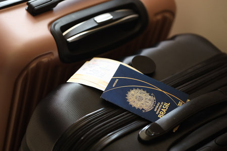 Federative Republic of Brazil passport with tickets lies on touristic suitcase close up in airport waiting hall. Travel worldwide and international tourism conceptの写真素材