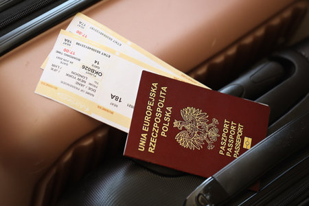 Polish passport with tickets lies on touristic suitcase close up in airport waiting hall. Travel worldwide and international tourism conceptの写真素材