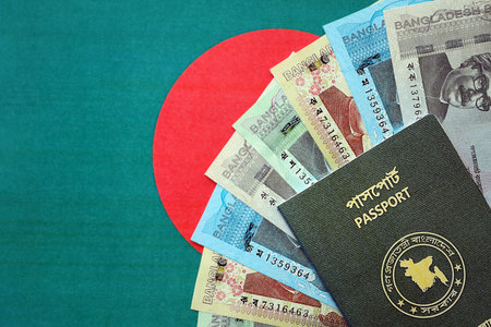 Bangladeshi taka money bills in big amount and passport lies on Bangladesh flag close up. Finance and banking conceptの写真素材