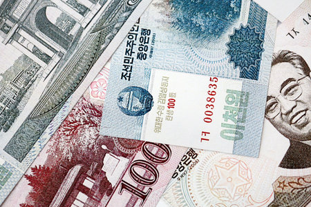 North Korean won money bills in big amount lies on white color table close up. Finance and banking conceptの写真素材