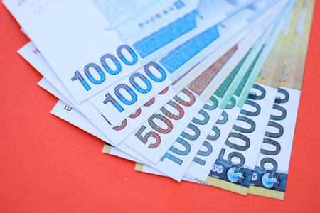 South Korean won money bills in big amount lies on red color table close up. Finance and banking conceptの写真素材
