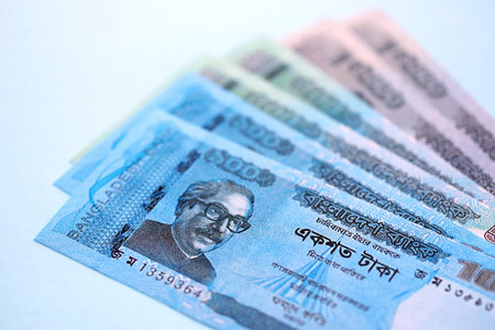 Bangladeshi taka money bills in big amount lies on teal color table close up. Finance and banking...