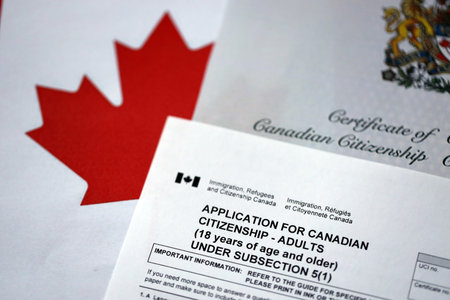 Canadian certificate of citizenship and application on Canadian flag close upの写真素材
