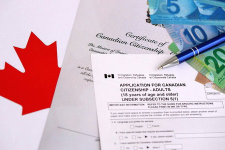 Canadian certificate of citizenship and application with money on Canadian flag close upの写真素材
