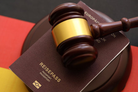 Germany passport book and judgement hammer on Germany flag close upの写真素材