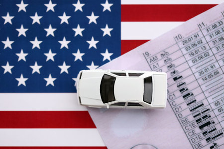 Toy car on driving license close up on United States flag. Driving license specimen card and US flagの写真素材