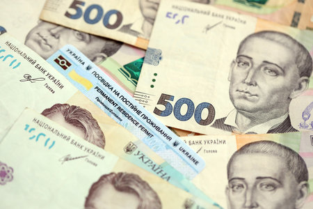 Ukrainian residence permit card or permanent resident card on Ukrainian money close upの写真素材