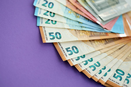 Big amount of european euro currency money notes on purple color table close up. Concept of business...