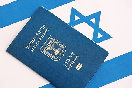 Israel passport on flag. The current Israel biometrical pass lies on flag close up. The concept of citizenship in Israelの写真素材