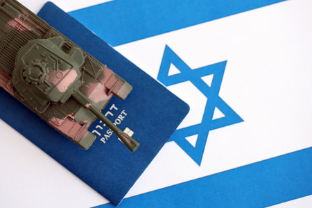 Passport and toy tank on flag. The current passport and tank lies on flag close up. The concept of army funds and weapons salesの写真素材